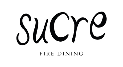 The word "Sucre" is written in an elegant, artistic font with a unique design, and below it, "FIRE DINING" is written in a smaller, simple font. The overall design gives a sophisticated and upscale impression,